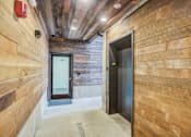 Thumbnail 4 of 11 - a hallway with two doors in a wood walled building