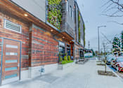 Thumbnail 3 of 11 - the side of a building with a sidewalk and a parking meter