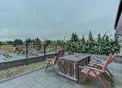 Thumbnail 8 of 11 - a patio with a table and chairs on a balcony