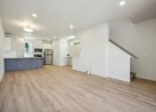 Thumbnail 28 of 42 - the living room and kitchen of a house with white walls and wood floors