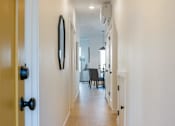 Thumbnail 4 of 4 - A hallway with a black door and a mirror on the wall.