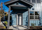 Thumbnail 2 of 55 - A blue house with a white door and a small porch.