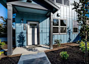 Thumbnail 21 of 55 - A blue house with a white door and windows.
