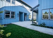 Thumbnail 15 of 55 - A blue building with a white door and windows.