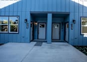 Thumbnail 17 of 55 - A blue building with a white door and windows.