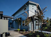 Thumbnail 1 of 55 - A blue house with a white door and windows.