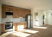 Thumbnail 27 of 55 - A kitchen with wooden cabinets and a stainless steel refrigerator.