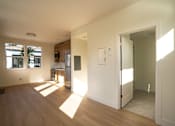 Thumbnail 28 of 55 - A room with wooden floors and white walls with sunlight coming through the windows.