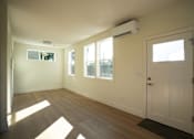 Thumbnail 30 of 55 - A room with a white door, windows, and a wall-mounted air conditioner.