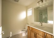 Thumbnail 31 of 55 - A bathroom with a toilet, sink, and mirror.