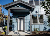 Thumbnail 5 of 55 - A blue house with a white door and windows.