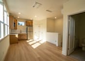 Thumbnail 38 of 55 - A kitchen with wooden floors and white walls.