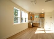 Thumbnail 39 of 55 - A kitchen with wooden floors and white walls.