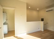 Thumbnail 41 of 55 - A room with a white door and a white wall with a black speaker on the wall.