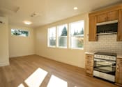 Thumbnail 43 of 55 - A kitchen with a stove top oven and wooden cabinets.
