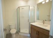 Thumbnail 44 of 55 - A white toilet sits next to a walk-in shower in a bathroom.