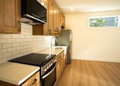 Thumbnail 48 of 55 - A kitchen with wooden cabinets and a black stove top.