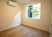 Thumbnail 49 of 55 - A room with a window and wooden flooring.