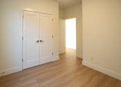 Thumbnail 52 of 55 - A room with a white door and a wooden floor.