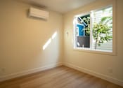 Thumbnail 54 of 55 - A room with a window and an air conditioner on the wall.