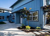Thumbnail 7 of 55 - A blue building with a white door and windows.