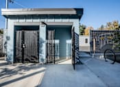 Thumbnail 8 of 55 - A blue building with a black gate and a white door.