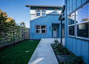 Thumbnail 3 of 55 - A blue house with a white fence and a green lawn.