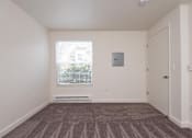 Thumbnail 3 of 17 - A room with a carpeted floor and a window with blinds.