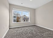 Thumbnail 22 of 30 - A room with a large window and grey carpet.