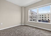 Thumbnail 19 of 30 - A room with a large window overlooking a building.