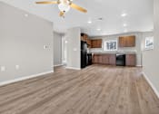 Thumbnail 13 of 30 - A spacious kitchen with wood flooring and a ceiling fan.