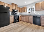 Thumbnail 12 of 30 - A kitchen with black appliances and wooden cabinets.