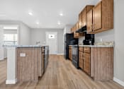 Thumbnail 11 of 30 - A kitchen with wooden cabinets and appliances.