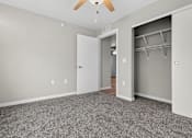 Thumbnail 15 of 30 - A room with a ceiling fan and a doorway leading to another room.
