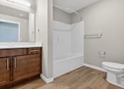 Thumbnail 26 of 30 - A bathroom with a toilet, sink, and bathtub.