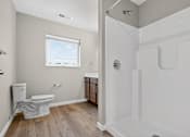Thumbnail 25 of 30 - A white toilet is in a bathroom with a walk-in shower.