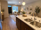 Thumbnail 5 of 16 - A modern kitchen with a large island and a view of the backyard.