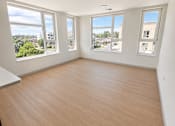 Thumbnail 10 of 13 - A room with wooden flooring and three windows.