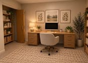 Thumbnail 12 of 16 - A home office with a desk, chair, and two framed pictures on the wall.