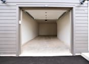 Thumbnail 21 of 22 - A garage door is open to reveal a clean, empty garage inside.