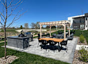 Thumbnail 4 of 22 - A patio with a table and chairs under a pergola.