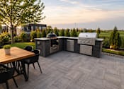 Thumbnail 6 of 31 - A patio with a table and chairs and a grill.