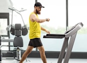 Thumbnail 8 of 8 - A man on a treadmill in a gym.