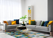 Thumbnail 4 of 8 - A living room with a sofa, a small table, and a colorful rug.