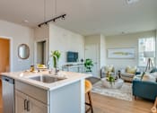Thumbnail 17 of 22 - A modern kitchen with a white countertop and stainless steel appliances.
