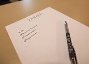 Thumbnail 23 of 30 - A to do list with a pen on a table.