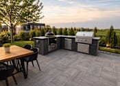 Thumbnail 5 of 30 - A patio with a table, chairs, and a grill.