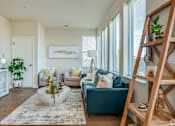 Thumbnail 17 of 30 - A living room with a blue couch and a white coffee table.