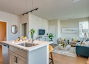 Thumbnail 18 of 30 - A modern kitchen with a white countertop and a sink.