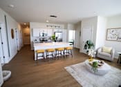 Thumbnail 6 of 30 - A modern kitchen with a white island and wooden floors.